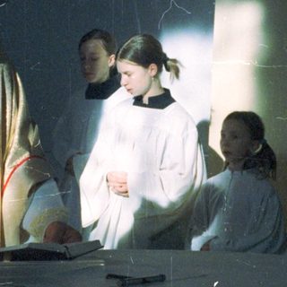Priest and altar servers at a religious ceremony.