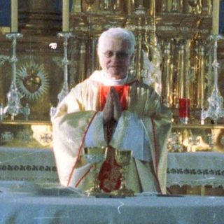 Pope performing a ceremony at an ornate altar.