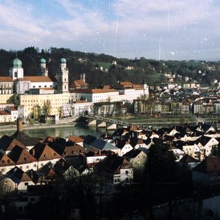Scenic town with abbey, river, and surrounding hills.