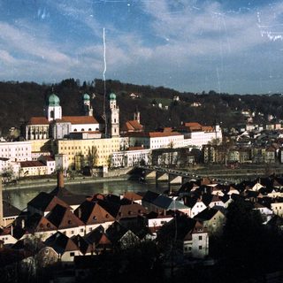 Monastery and town nestled along a river with hills.