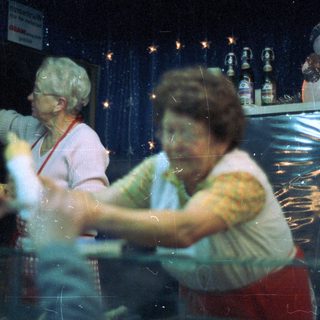 Two women working behind a counter with decorations.