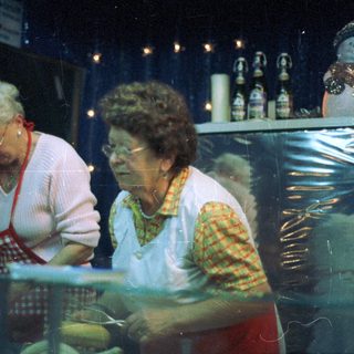 Two women working behind a bakery counter.