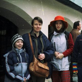 A family stands outdoors on a possibly rainy day.
