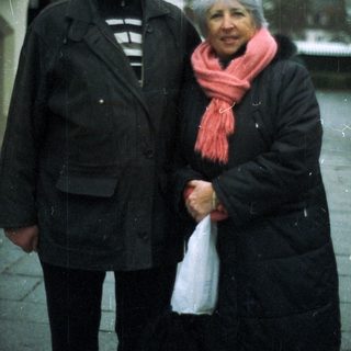An older couple stands outside, bundled up against the cold.