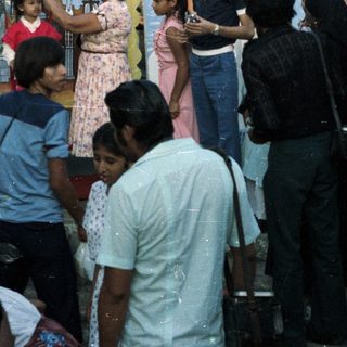 Group gathers before a mural, someone holds a statue.