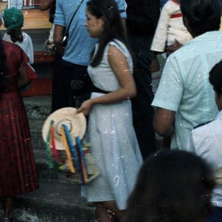 Group of people gathered before a religious mural outdoors.