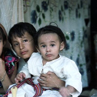 Here's a brief summary of the image: Four children are posing for a portrait indoors.