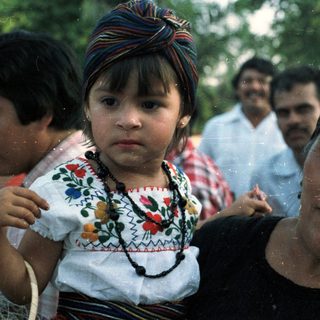 A woman carries a child with traditional clothing.