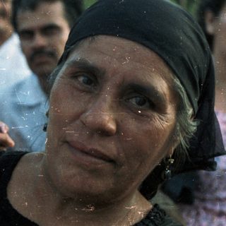 A woman carries a child with traditional clothing.