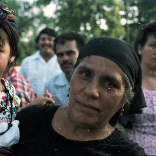 A woman carries a child with traditional clothing.