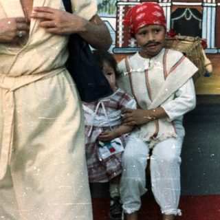 Woman, child, and man posed before a mural.