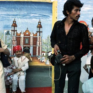 Woman, child, and man posed before a mural.