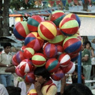 Crowded gathering near an altar with decorations and balloons.