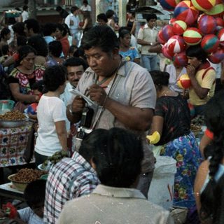 Crowded gathering near an altar with decorations and balloons.