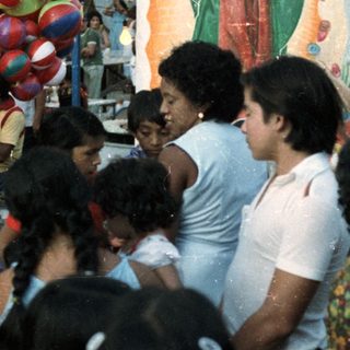 Crowded gathering near an altar with decorations and balloons.