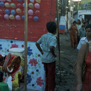 Children playing a game involving balloons and buckets.