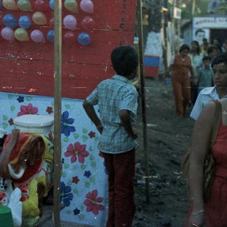 Children playing a game involving balloons and buckets.