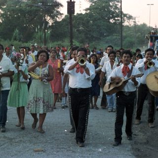 Parade or procession with musicians and onlookers.