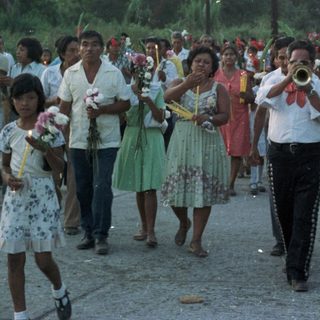 Parade or procession with musicians and onlookers.