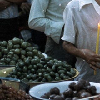 People gathered, holding candles, seemingly in a procession.
