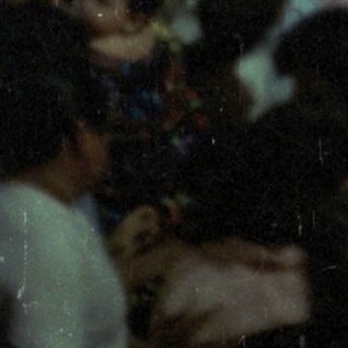 Crowded gathering in front of a decorated building or altar.