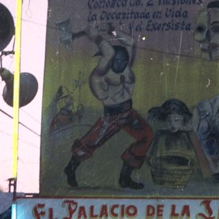 Palacio de la Ilusion sign with people standing nearby.