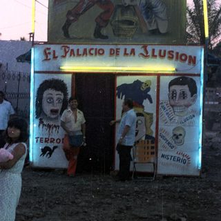 Palacio de la Ilusion sign with people standing nearby.
