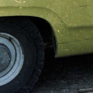 Men converse near a yellow truck with inspection signage.