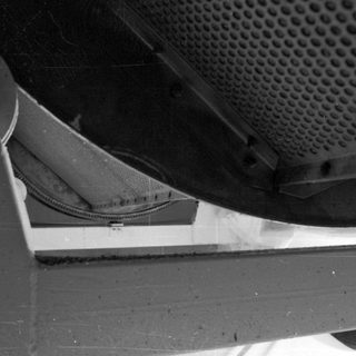 Close-up of a ventilation grill and surrounding metal structure.