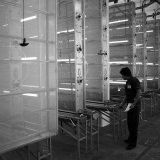 Man inspecting machinery in a spray painting booth.