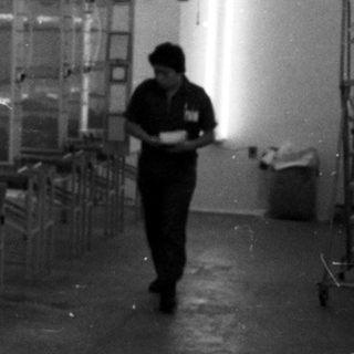 Industrial facility with numerous drying racks and a worker.
