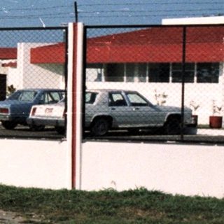 Here's a brief summary of the image: Exterior view of a facility labeled "Metapa" with a vehicle.