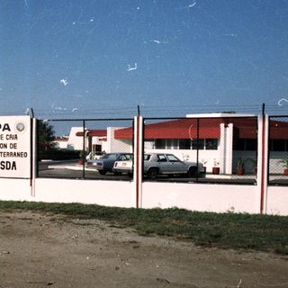 Here's a brief summary of the image: Building with signage, likely related to insect breeding/sterilization.