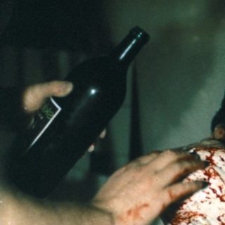 Here's a brief, factual summary of the image: Person handling a bloody organ in a yellow bucket. If you need more details or