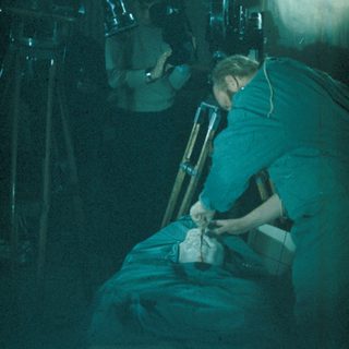 Surgeon performing a procedure in an operating room.