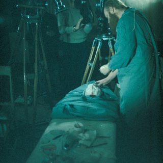 Film crew member adjusting a prop during a scene.