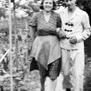 Couple walking along a path in a garden.