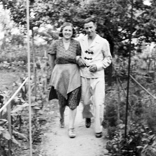 Couple walking along a path in a garden.