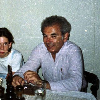 Family seated at a table with food and drink.