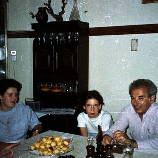 Family seated at a table with food and drink.