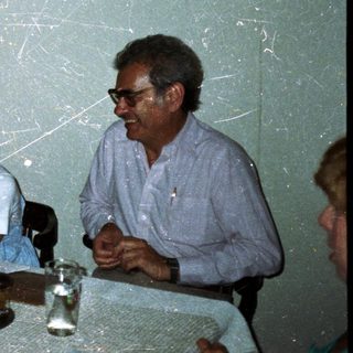 Family seated at a table, sharing food and conversation.