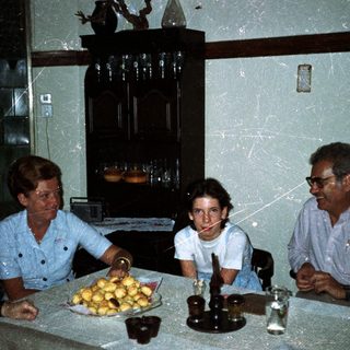 Family seated at a table, sharing food and conversation.