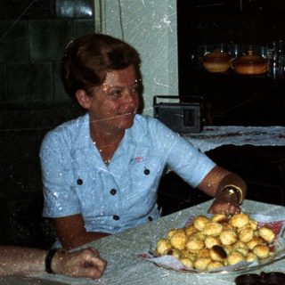 Family seated at a table, sharing food and conversation.