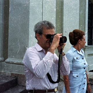 Man taking a photo while a woman stands nearby.