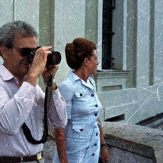 Man taking a photo while a woman stands nearby.