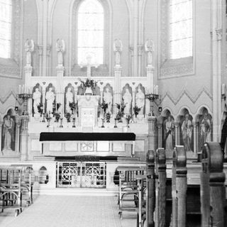 Black and white image of a church altar and pews.
