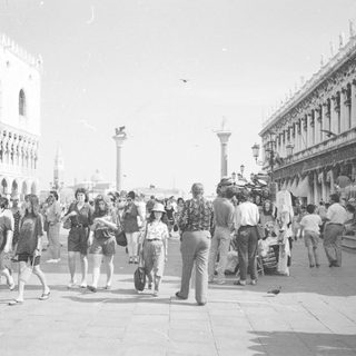 Crowded square with buildings and people in Venice, Italy.
