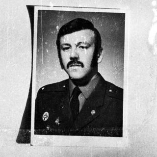 Here's a brief summary of the image: Moustached man in military uniform, displayed in a photo.