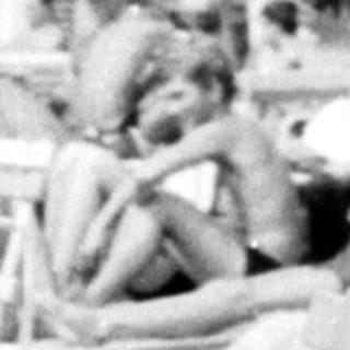 Here's a brief summary of the image: Child playing with a ball near a pool area.
