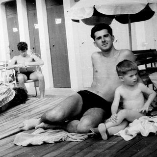 Black and white image of people relaxing on a deck.
